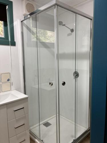 a shower with a glass enclosure in a bathroom at School Cottage in Walhalla