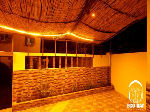 a room with a stone wall and a ceiling with lights at Eco Bay Surf Camp in Aourir