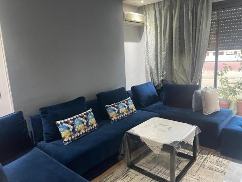 a blue couch in a living room with a table at Golden Horn Apartment in Agadir