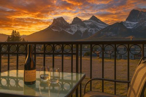 a bottle of wine sitting on a table with two glasses at Luxury 3B Mountain Views- Pool & Hot Tub -Sleeps 10 in Canmore