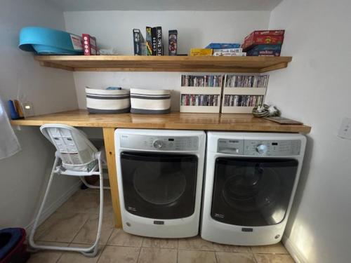 two washing machines sitting under a table with a shelf at Hot Tub-EV-AC-Kid Friendly-Arcade Game-Lake Access in Lake Arrowhead