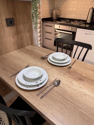 a wooden table with plates and utensils on it at Begonvil Life in Gazipasa