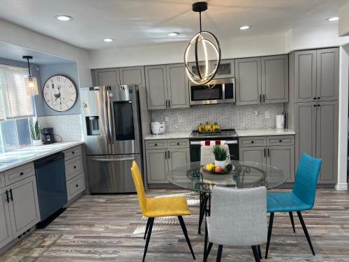 a kitchen with a glass table and yellow chairs at DIA Layover B&B in DEN