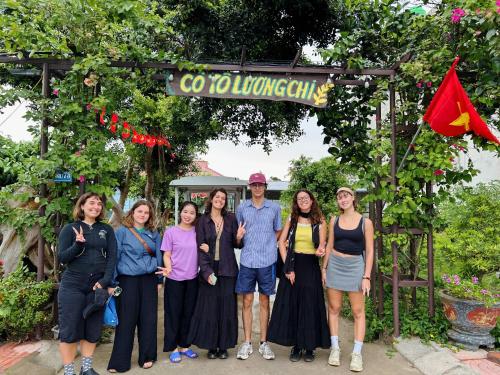 a group of people posing for a picture under a sign at Cô Tô Lương Chi in Quang Ninh