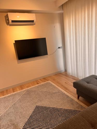 a living room with a flat screen tv on the wall at Begonvil Life in Gazipasa