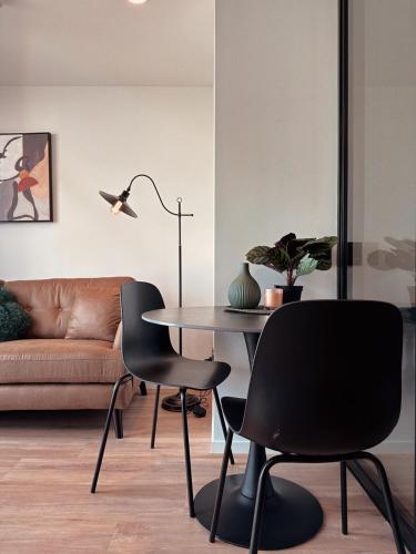 a living room with a table and chairs and a couch at Elegant City Center Stay, Stylish Living in Auckland