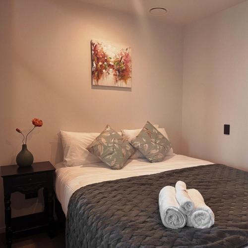 a bedroom with a bed with two towels on it at Elegant City Center Stay, Stylish Living in Auckland