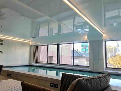a large swimming pool with a large window at Elegant City Center Stay, Stylish Living in Auckland