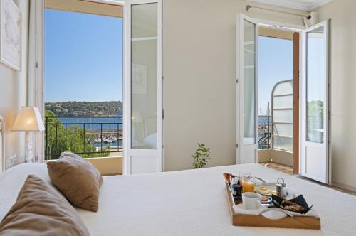 a bedroom with a bed with a view of the ocean at Hotel De La Darse in Villefranche-sur-Mer