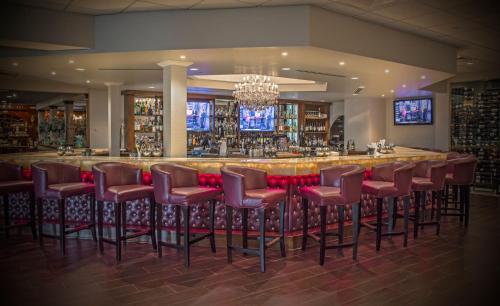 een bar met rode krukken in een kamer bij The Delavan Hotel in Buffalo