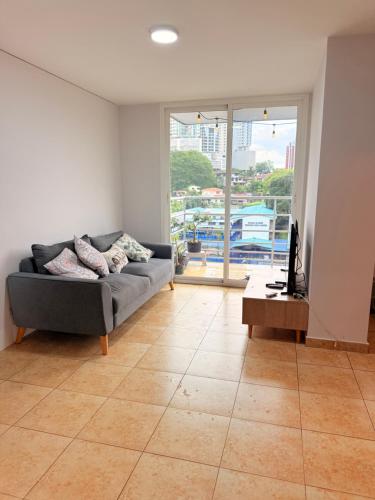 a living room with a couch and a table at Hermoso apartamento para sentirse como en casa in Panama City