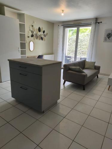 - un salon avec une commode, une chaise et un canapé dans l'établissement Le cocon d'Elodie, à Belley