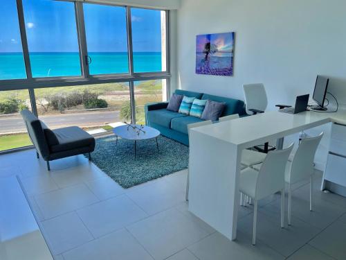 a living room with a blue couch and a table at Azure Beach Residences in Palm-Eagle Beach