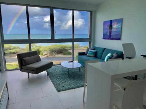 a living room with a couch and chairs and a rainbow at Azure Beach Residences in Palm-Eagle Beach