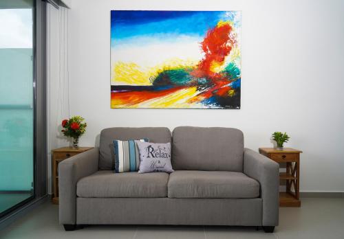 a couch in a living room with a painting on the wall at Azure Beach Residences in Palm-Eagle Beach
