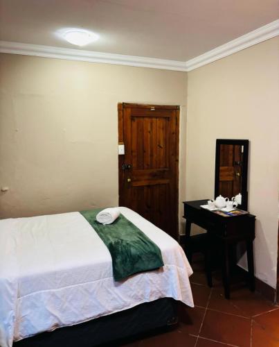 1 dormitorio con cama y mesa con espejo en De Rock view lodge, en Vosburg