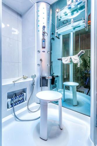 a bathroom with a shower with a table and a stool at Villa Roses Apartments & Wellness in Ičići