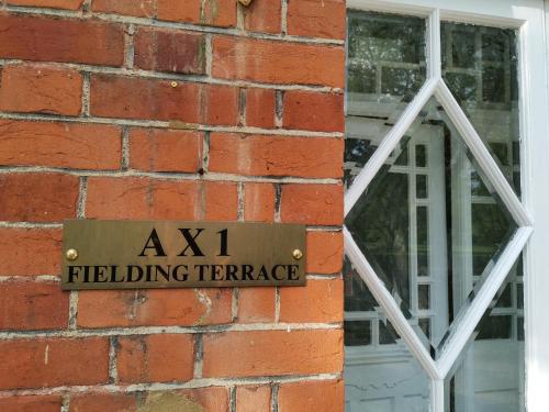 a sign on the side of a brick building with a window at Ax 1 Bed and Breakfast in London