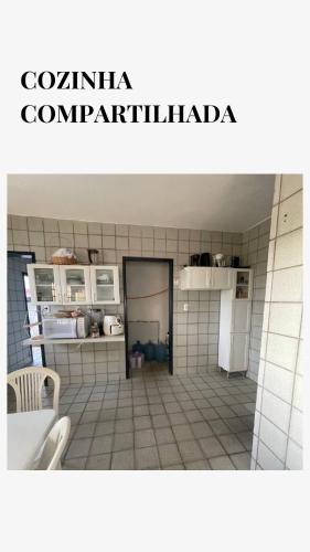 a kitchen with a white tiled floor and a white refrigerator at Tree Suíte Comfort in Garanhuns