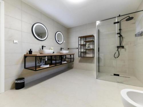 a bathroom with two sinks and a shower at Four Bedroom Villa With Hot Tub in Pašman