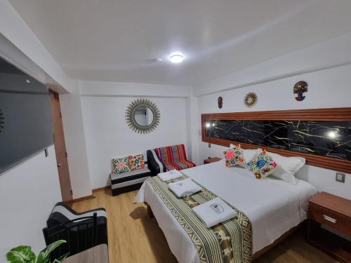 a bedroom with a large bed and a couch at Hotel Hatun Sumac Wasi in Sicuani
