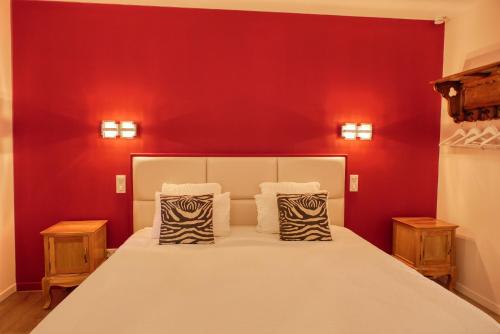 a bedroom with a large bed with red walls at Les Chambres du Hameau in Gordes