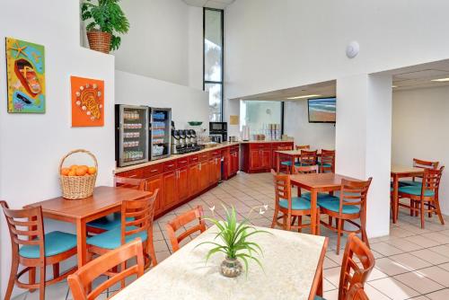Un restaurante con mesas y sillas y un mostrador. en El Caribe Resort and Conference Center, en Daytona Beach