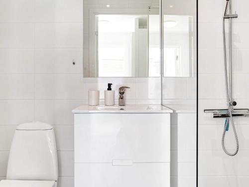 a white bathroom with a sink and a shower at Tranquil Designer Holiday Home in Læsø in Læsø