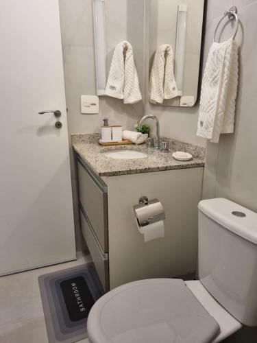 a bathroom with a toilet and a sink and mirror at Seu Refúgio Urbano na Bela Vista in Sao Paulo