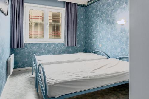 a hospital bed in a room with blue walls at Epsom 0402 in Sint-Idesbald