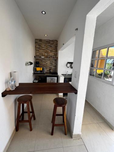 a kitchen with a counter and two stools at Casa Enna in Isla Mujeres