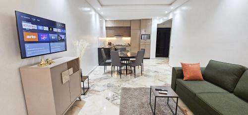 a living room with a couch and a dining room at Appartement 2 chambres à Guéliz avec terrasse et parking in Marrakech