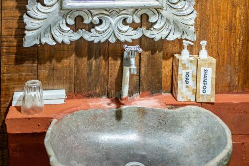 a sink in a bathroom with two soap bottles at Yoga Maya Villa in Gianyar