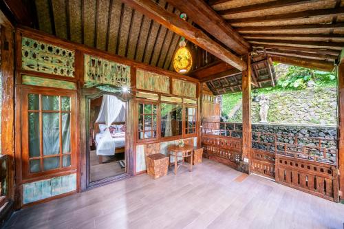 a wooden room with a bed and a table at Yoga Maya Villa in Gianyar