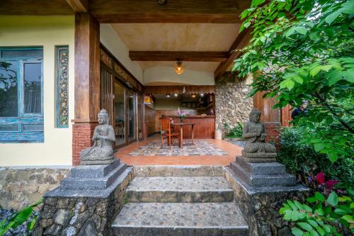 a house with a porch with stone statues on it at Yoga Maya Villa in Gianyar
