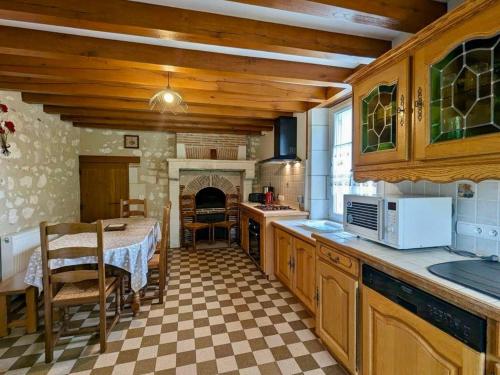 une cuisine avec une table et une cuisinière four supérieur dans l'établissement Gîte familial 12 pers. proche Valençay, ZooParc de Beauval et Châteaux de la Loire, parc arboré et jeux - FR-1-591-113, à Vicq-sur-Nahon