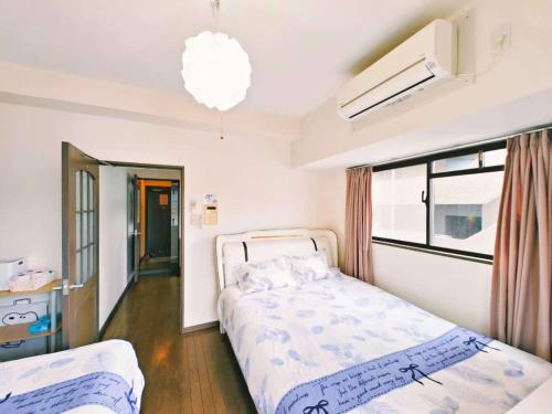 um quarto com duas camas e uma janela em Lucky sky903周围设施配套齐全1Ldk可容纳5人 徒步心斋桥商圈 高楼层俯瞰大阪 em Osaka