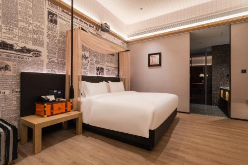 a bedroom with a large white bed and a wall with newspapers at Arthur Hotel Liwan COCO Park Dongsha Metro Guangzhou-24H Coffee & Low Tea & Free Shuttle Bus For Canton Fair By Paco in Guangzhou