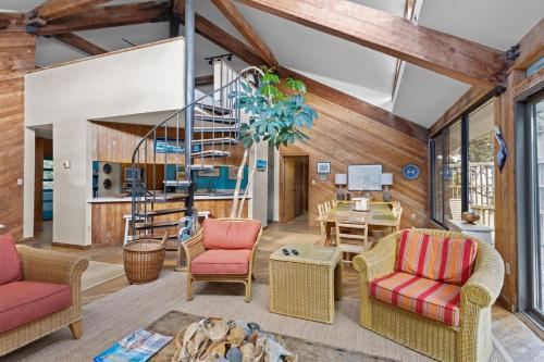 a living room with chairs and a spiral staircase at Beach Grove home in Pine Knoll Shores