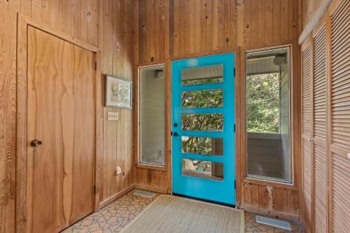 a blue door in a room with a window at Beach Grove home in Pine Knoll Shores