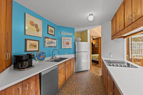 a kitchen with blue walls and a refrigerator at Beach Grove home in Pine Knoll Shores