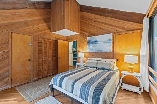 a bedroom with a bed and a wooden ceiling at Beach Grove home in Pine Knoll Shores