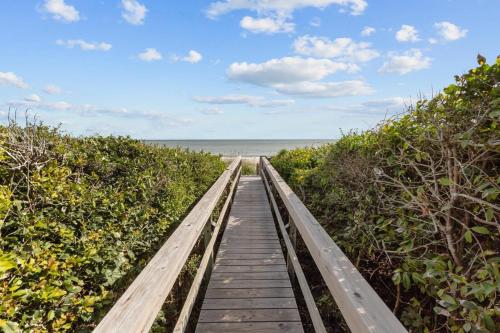 a wooden boardwalk leading to the beach at Beach Grove home in Pine Knoll Shores