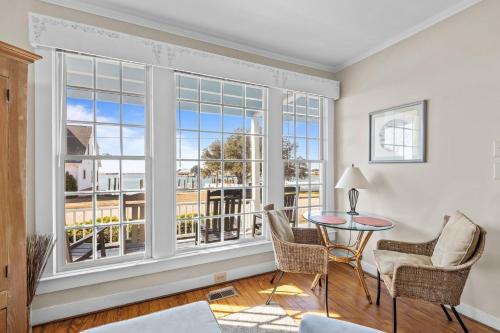 a living room with a table and chairs and windows at Condo on Front condo in Beaufort