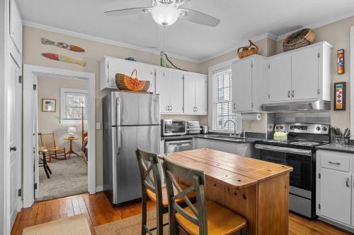 a kitchen with white cabinets and a wooden table at Condo on Front condo in Beaufort