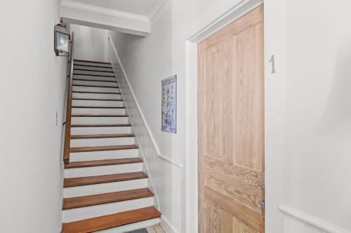 a staircase with a wooden door in a room at Condo on Front condo in Beaufort