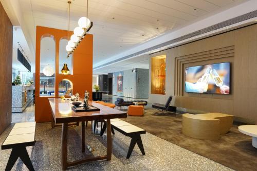 a living room with a dining table and a tv at Arthur Hotel Liwan COCO Park Dongsha Metro Guangzhou-24H Coffee & Low Tea & Free Shuttle Bus For Canton Fair By Paco in Guangzhou