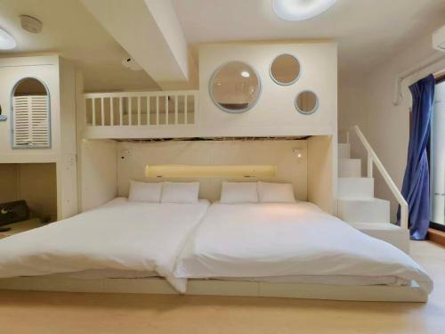 a bedroom with a large white bed and a staircase at Rest Collection Bentencho Osaka in Osaka