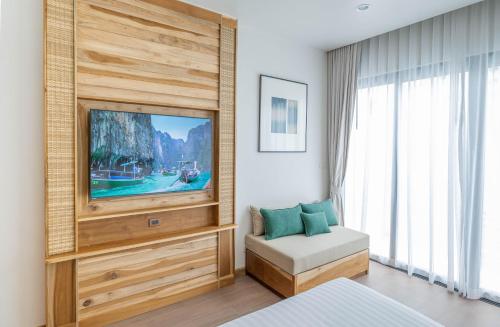 a bedroom with a tv and a bed and a couch at Phi Phi at Pier in Phi Phi Don