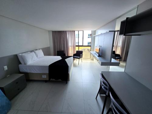 a hotel room with a bed and a desk at Unity, Cabo Branco Flat 324 in João Pessoa